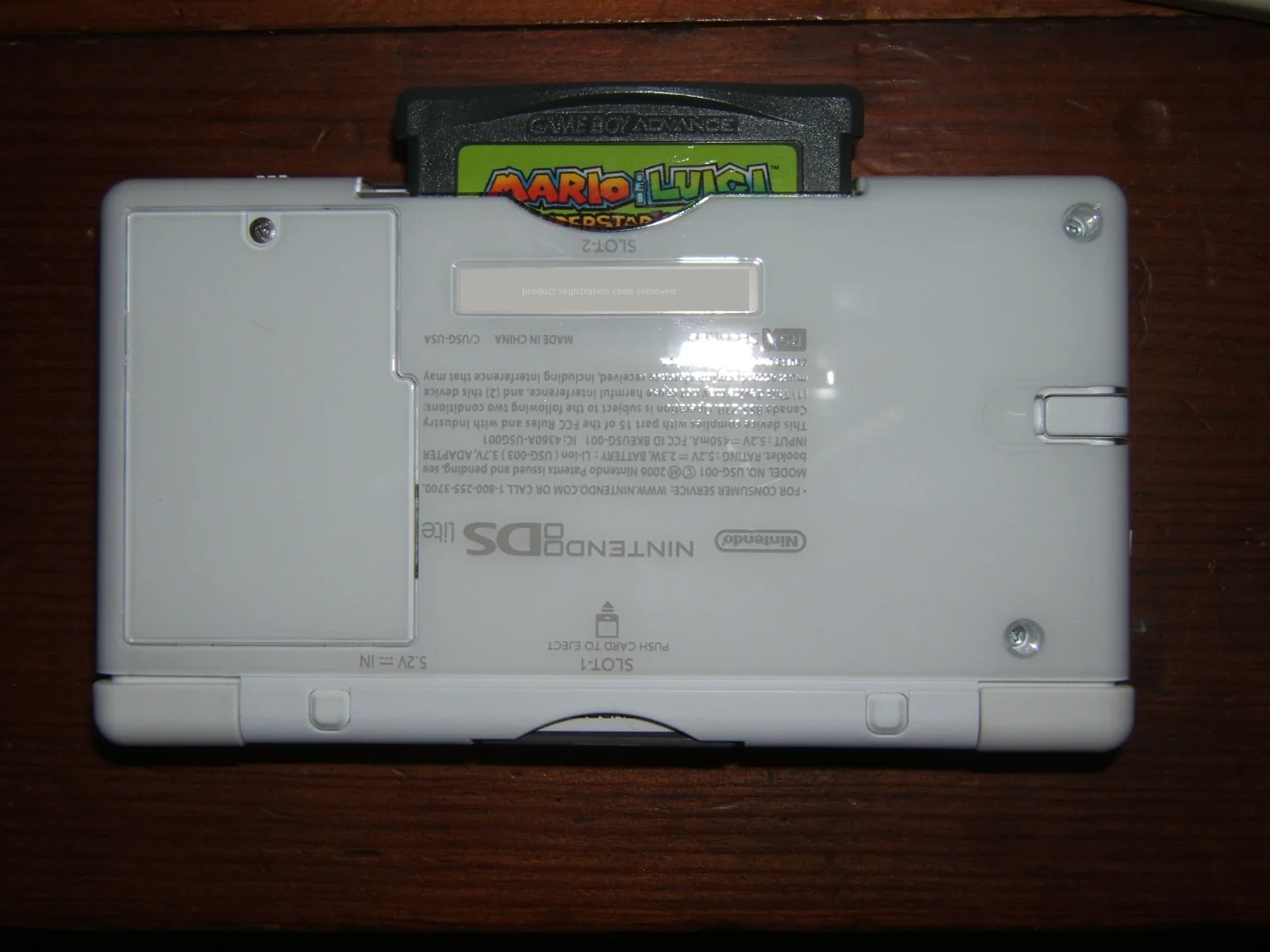 Witte Nintendo DS Lite met een Game Boy Advance-cartridge in de onderste sleuf